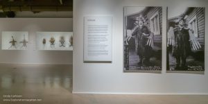 Part of the exhibit Yua: Henri Matisse and the Inner Arctic Spirit showing a reproduction of a historic picture of a Yup’ik shaman in Nushagak Village, Bristol Bay, Alaska, with re-united sets of masks in the background. It’s on exhibit in Phoenix