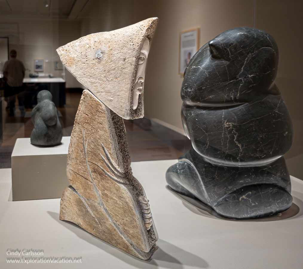 Photo of sculptures of kneeling women by Manasie Akpaliapik (Inuk - Ikpiarjuk/Arctic Bay, born 1955) Kneeling Woman 1980-2000, Carved whalebone with inset carved caribou bone AND Sheakin (Inuk - Kinngait/Cape Dorset) Woman Kneeling, 1971, Serpentine at the Eiteljorg in Indianapolis.